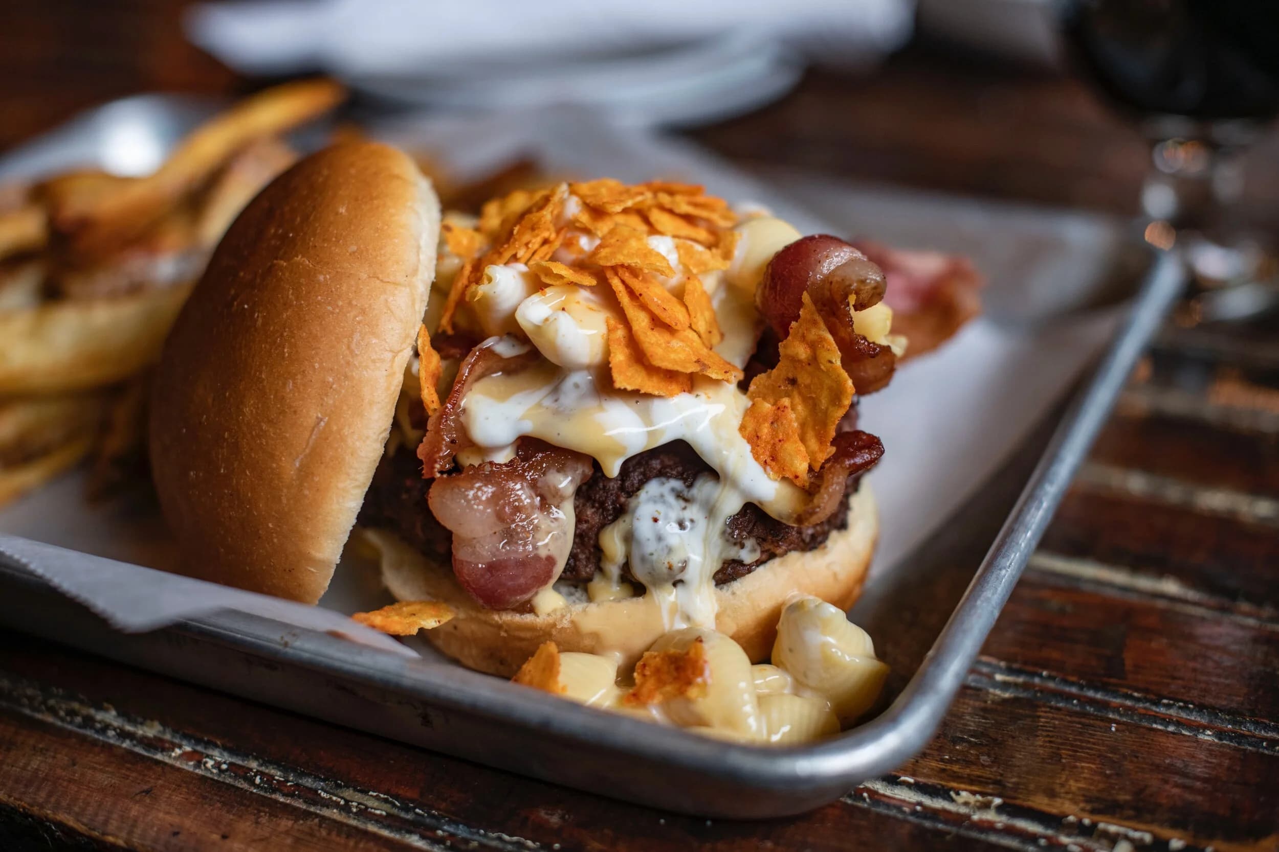 Cheeseburger topped with bacon, chips, and mac and cheese
